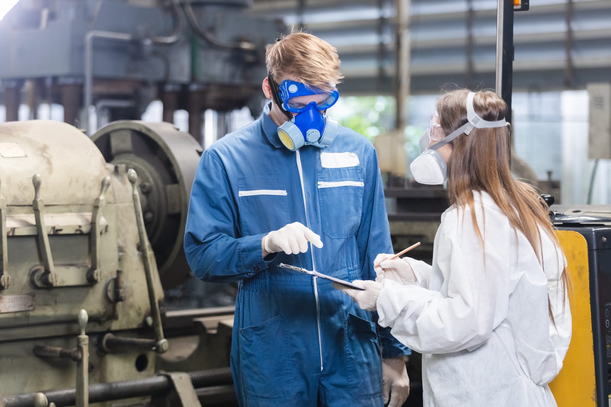 Two factory workers wearing respiratory protection