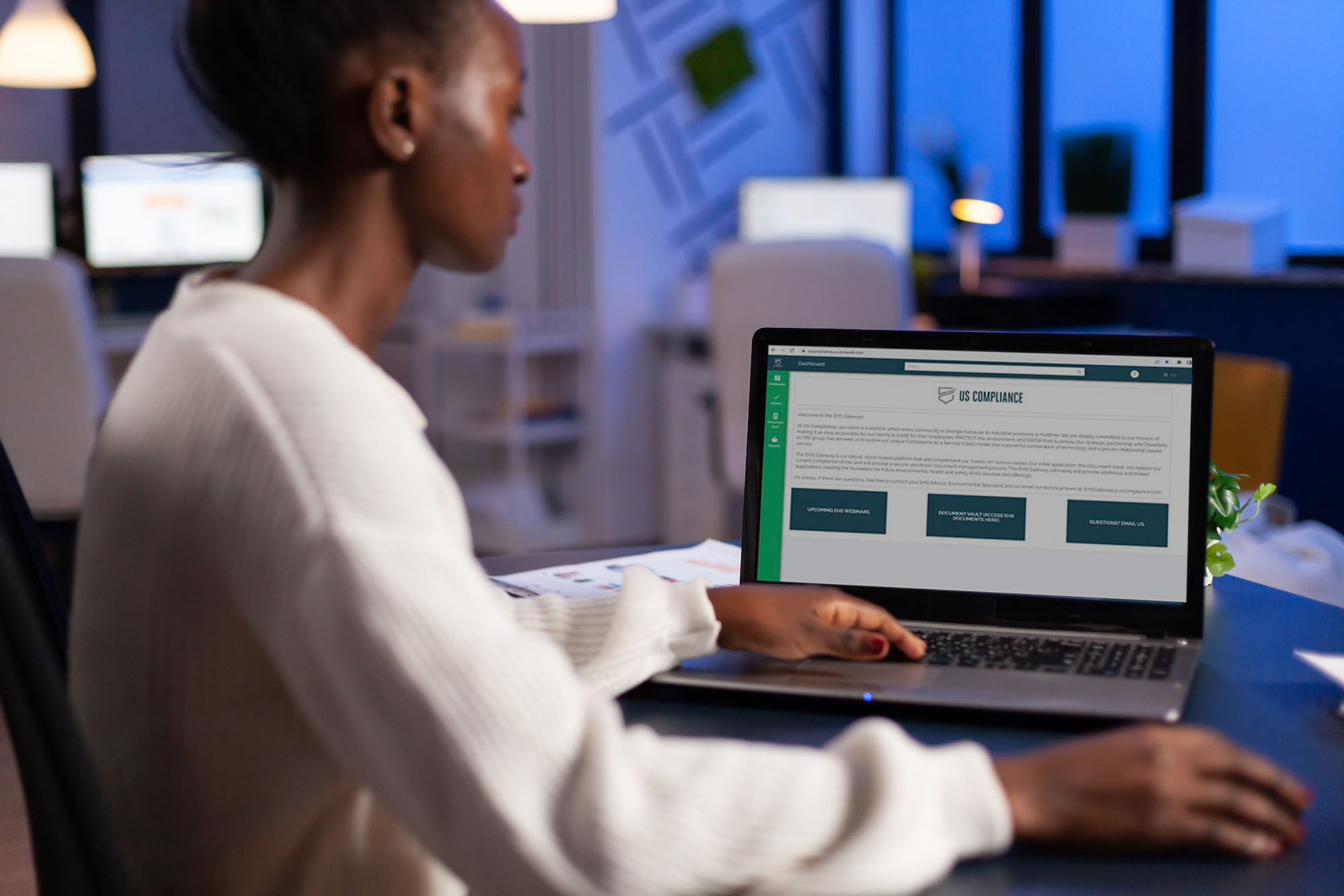 A woman sitting with a laptop showing the EHS Gateway