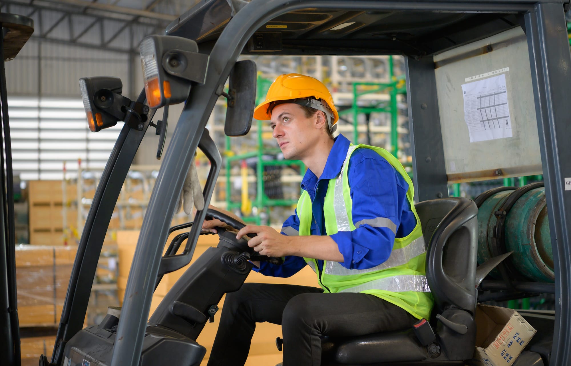 Worker in auto parts warehouse using a forklift