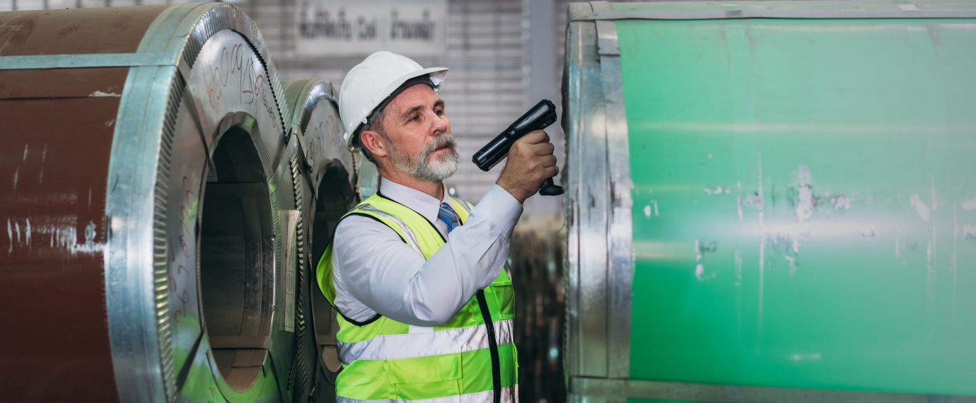 Man using infrared scanning on machine in factory